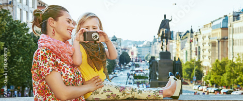 mother and daughter tourists with camera taking photo in Prague photo