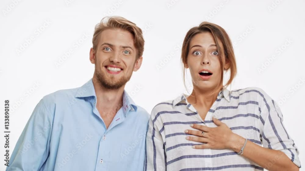 Young Caucasian couple actively surprising thrice and then smiling on white background Young Caucasian couple actively surprising thrice and then smiling on white background