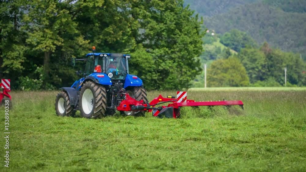 A big grass cutting machinery which is connected to the tractor is slowly cutting grass and we can see it flying everywhere around.
A big grass cutting machinery which is connected to the tractor is slowly cutting grass and we can see it flying everywhere around.