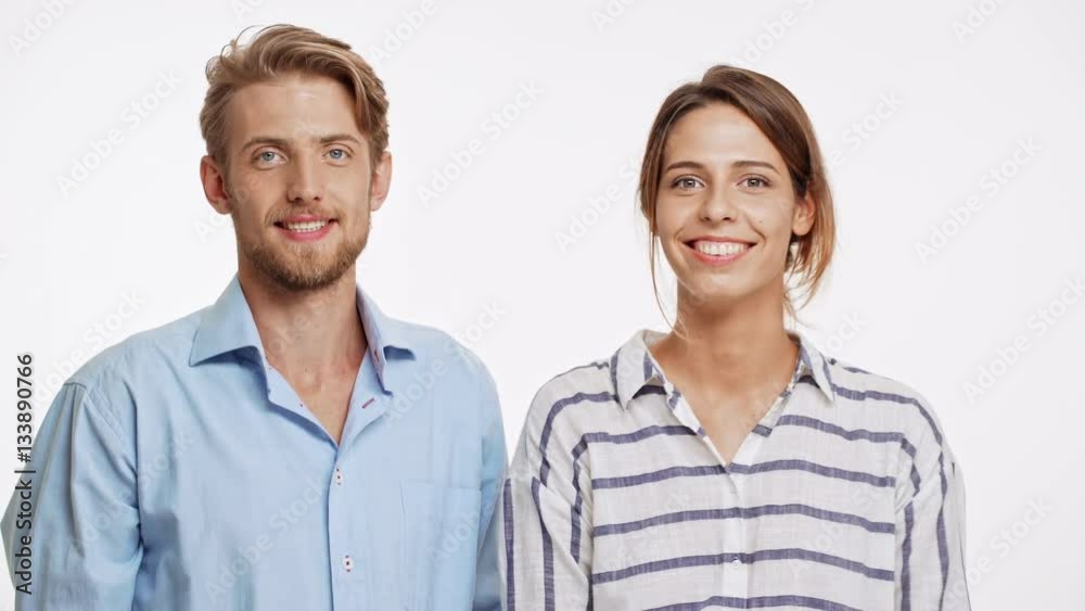 Young Caucasian couple gives high five with two hands to each other and smiling on white background Young Caucasian couple gives high five with two hands to each other and smiling on white background