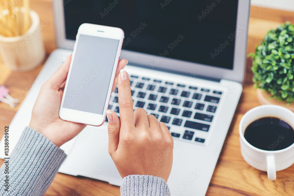 hand using smart phone on wooden background hand using smart phone on wooden background