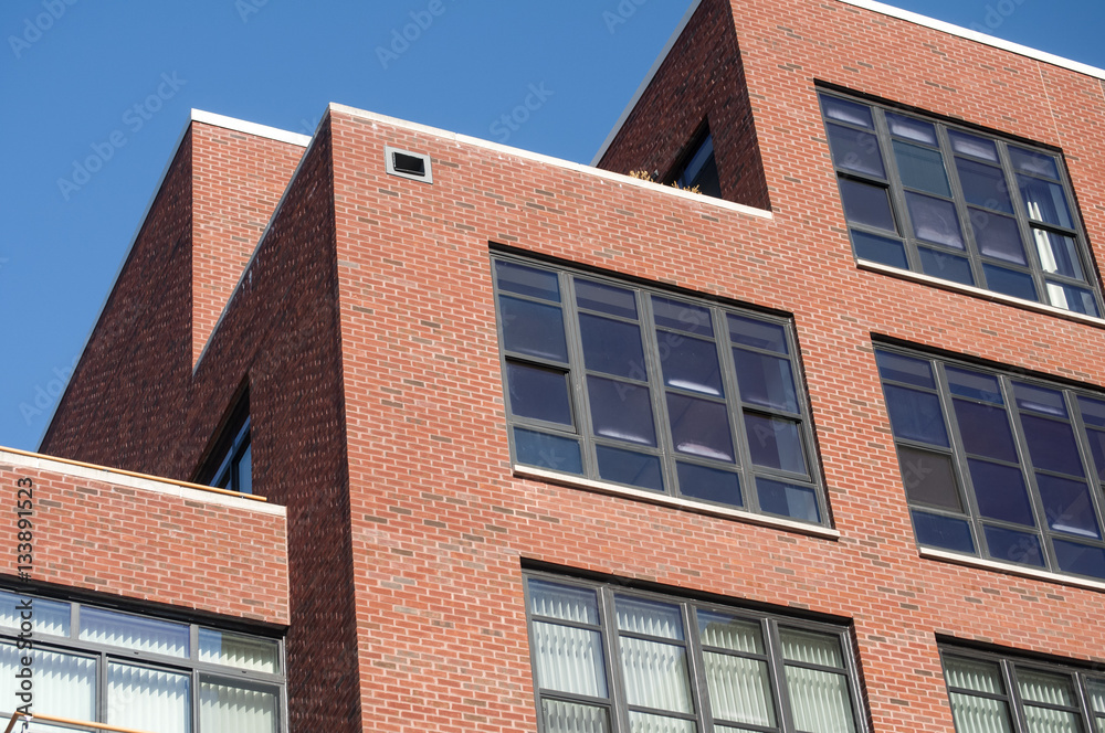 Modern industrial style residential building exterior with red bricks and glass windows