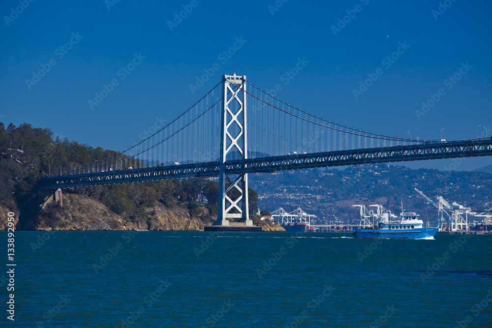 boat crossing under Oakland bridge