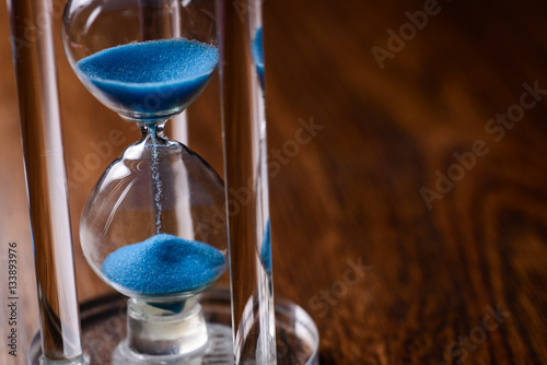 Classic hourglass with blue sand pouring