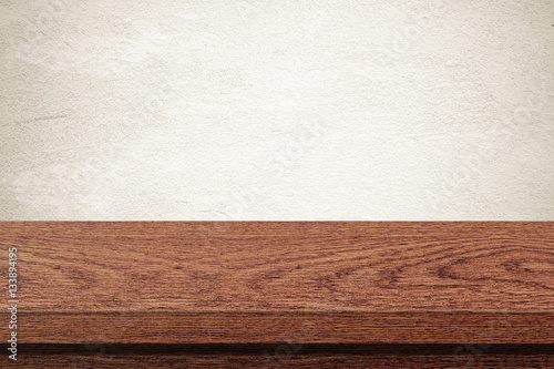 Empty wooden table over grunge cement wall background