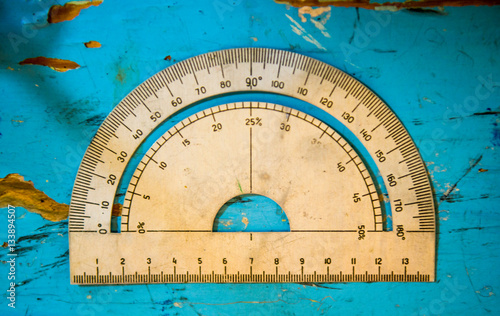 Overhead view of vintage protractor on blue table