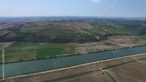 Aerial flight above green meadows and Danube river photo