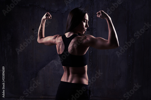 Close-up of woman in a good shape showing off her biceps, tricep