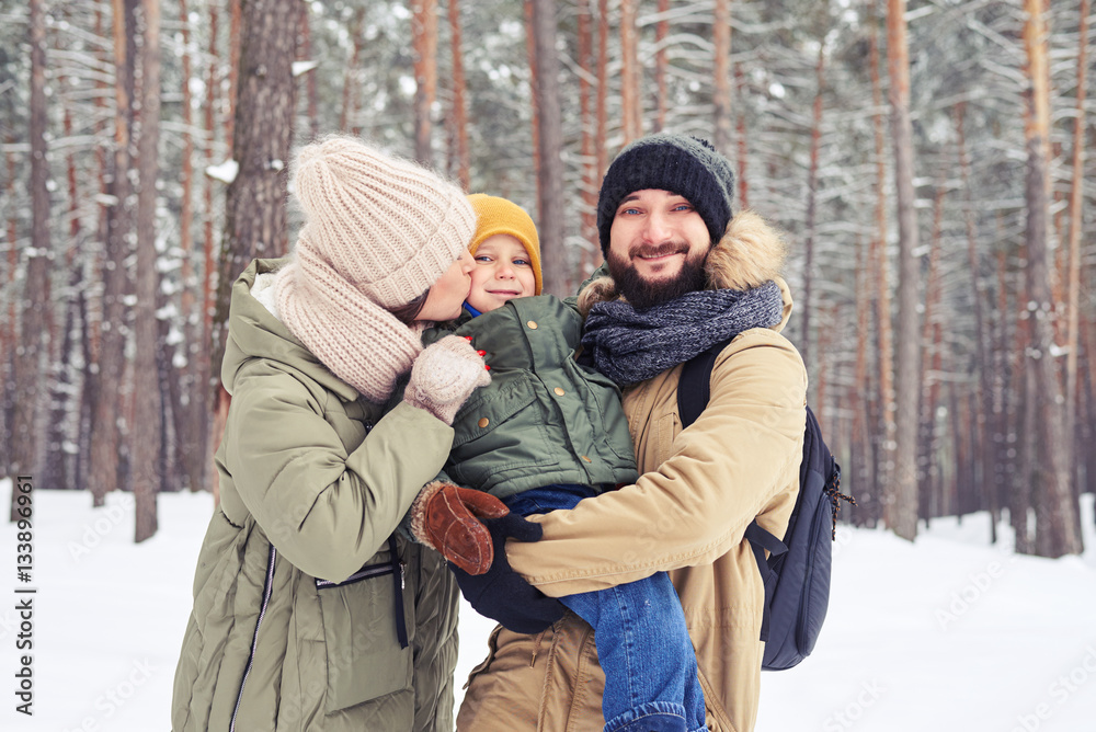 Merry family playing together on a sunny snowy day in the forest Merry family playing together on a sunny snowy day in the forest