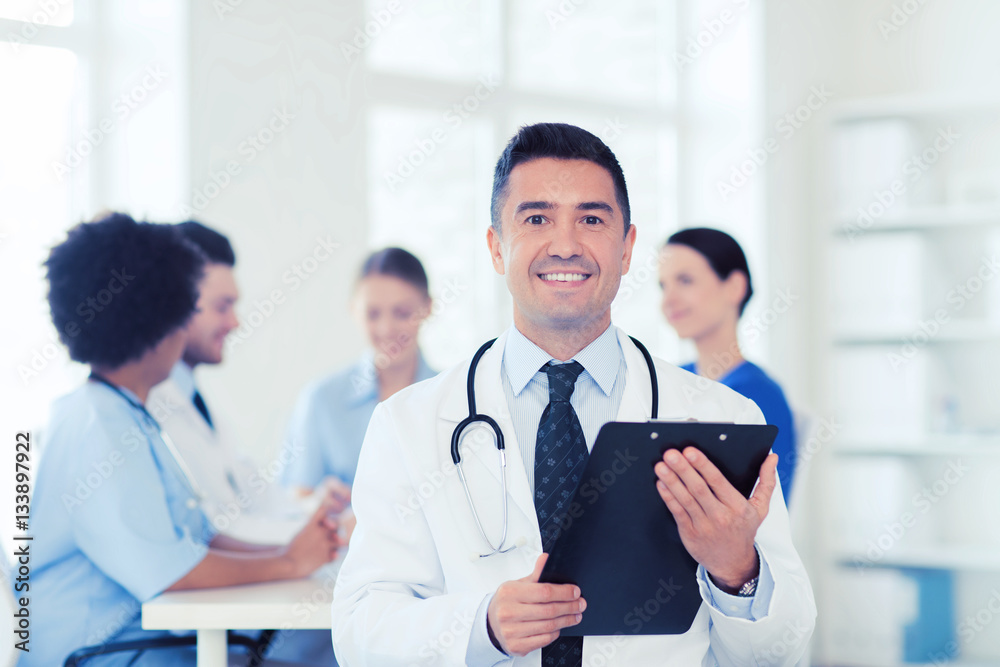 happy doctor with clipboard over medical team happy doctor with clipboard over medical team