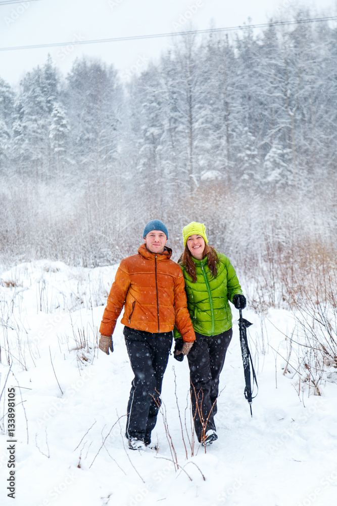 Active family walking in the winter forest.