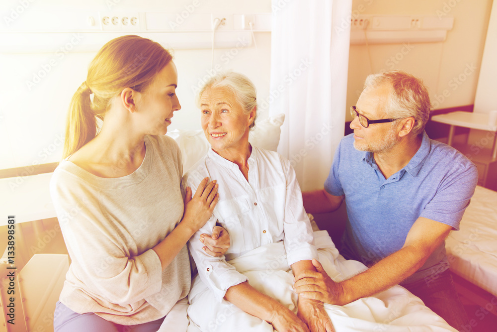 Fototapeta premium happy family visiting senior woman at hospital