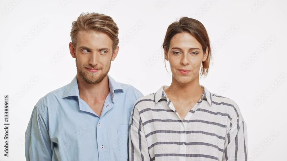 Beautiful Caucasian pair standing flirting ogle smiling laughing on white background in slowmotion