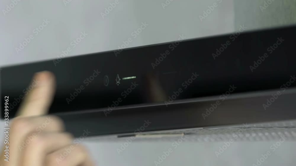 A young woman is adjusting the lights on a kitchen hood. She is pushing a few buttons.
A young woman is adjusting the lights on a kitchen hood. She is pushing a few buttons.