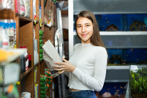 girl buying dry food for pets in shop