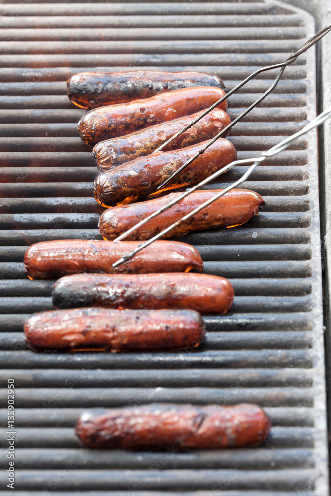 Row of sausages barbecuing on grill Row of sausages barbecuing on grill