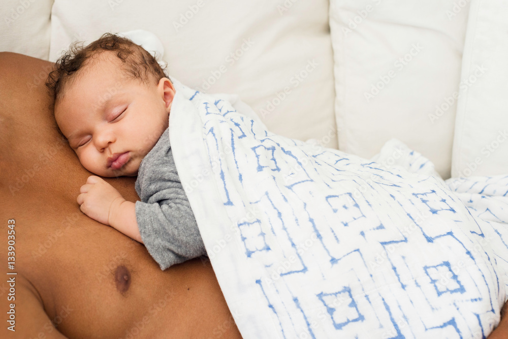 Baby sleeping on father's chest StockFoto Adobe Stock