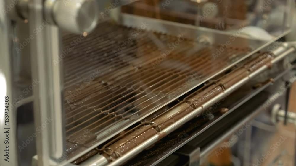 Conveyor line on a chocolate factory plant. Robotics automated food production. Automatic lines are used instead of human labor on factories and plants. Conveyor line on a chocolate factory plant. Robotics automated food production. Automatic lines are used instead of human labor on factories and plants.