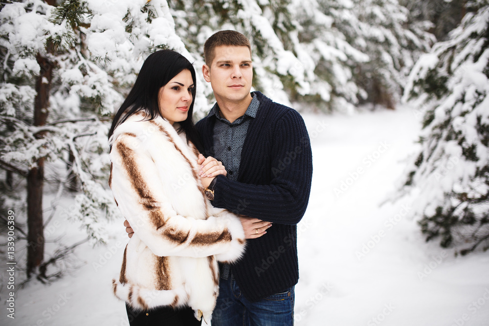 happy loving couple walking in snowy winter forest. Outdoor seasonal activities. Lifestyle capture. happy loving couple walking in snowy winter forest. Outdoor seasonal activities. Lifestyle capture.