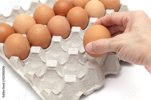 Obraz na płótnie Take some eggs from paper egg tray on white background isolated w salonie