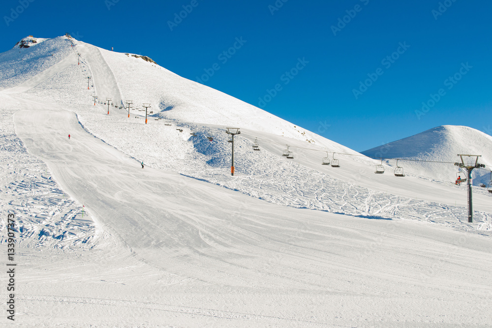 Winter mountains background with ski slopes and ski lifts. Skiing resort. Extreme sport. Active holiday. Free time concept.