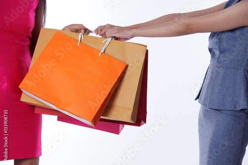 two women fight over shopping bag isolated on white background.