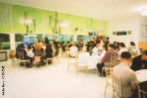 Blurred people in conference room or restaurant.