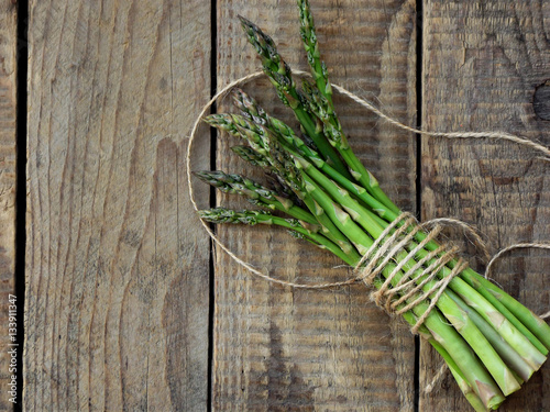 Fototapeta Naklejka Na Ścianę i Meble -  bunch of fresh green asparagus on a wooden background