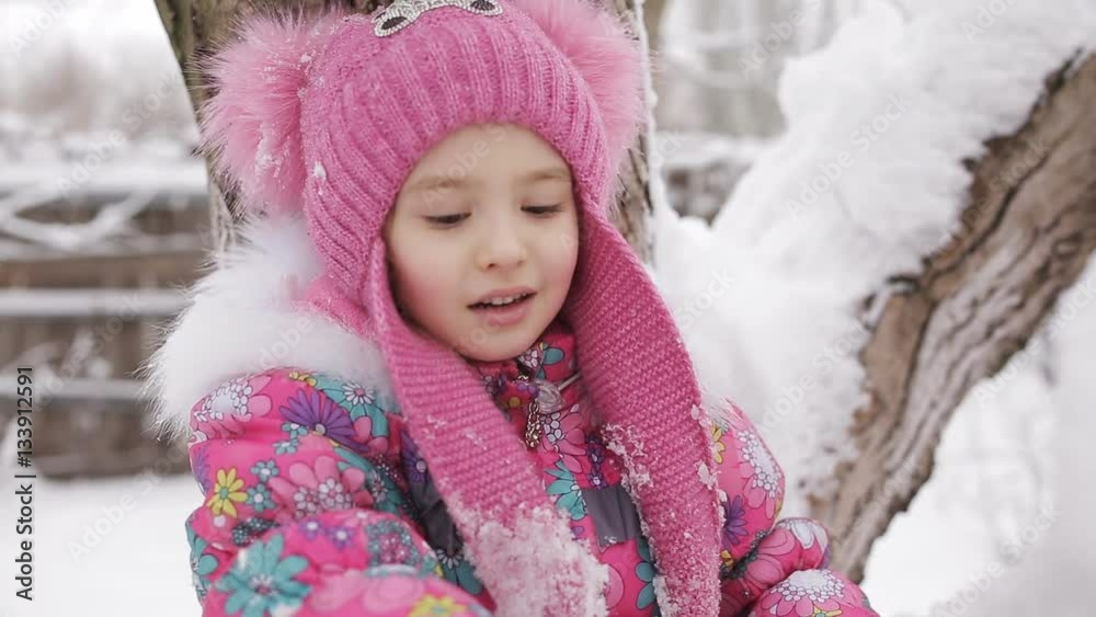Little girl swinging on the branches of trees, snow-covered Little girl swinging on the branches of trees, snow-covered