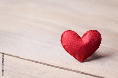 Valentines day concept of one heart shape decoration with old wood floor background.