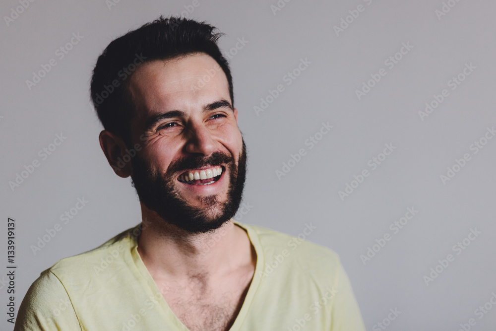 Young bearded man laughing, studio shot. Young bearded man laughing, studio shot.