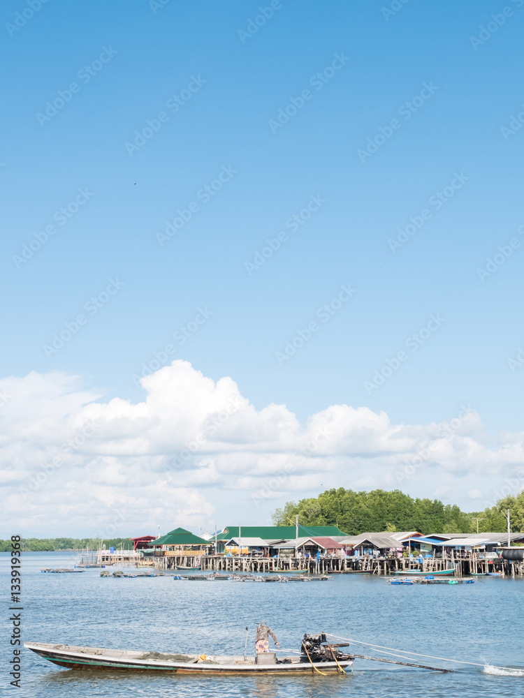 Boat on the river with many houses background and blue sky verti