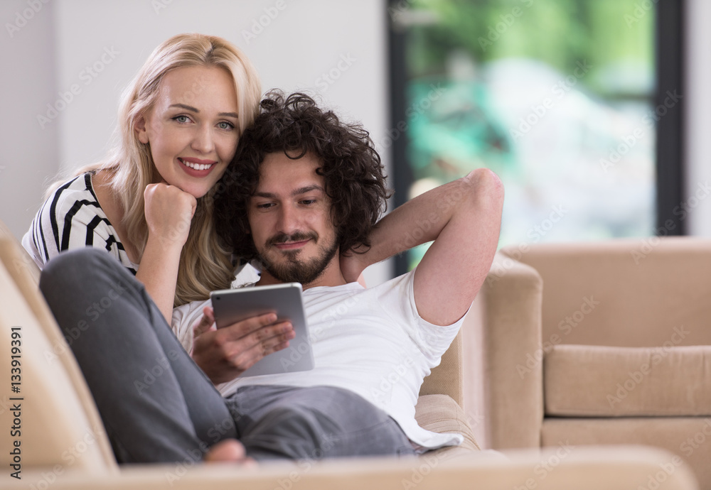 couple relaxing at home with tablet computers couple relaxing at home with tablet computers