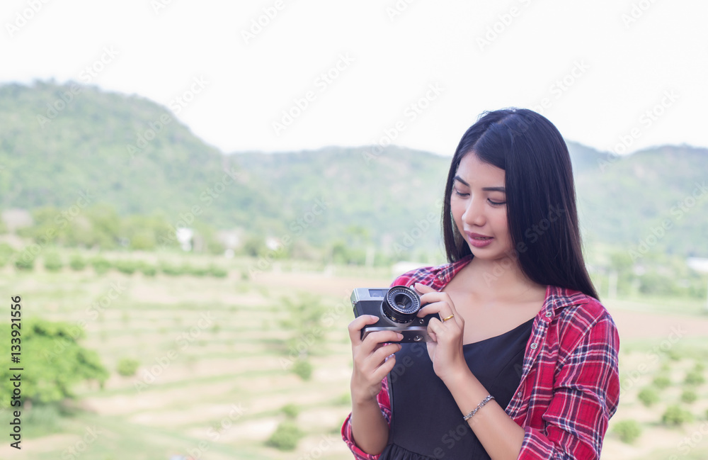 Young hipster woman photographer holding a vintage camera.