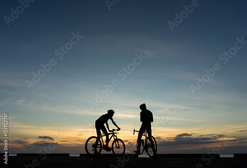 Silhouettes of Cyclists on bicycle at the ocean in the sunset sc