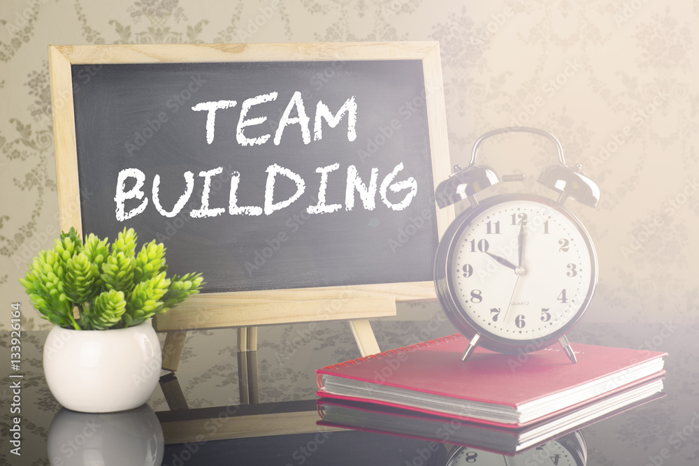 Team Building on blackboard with clock and flare