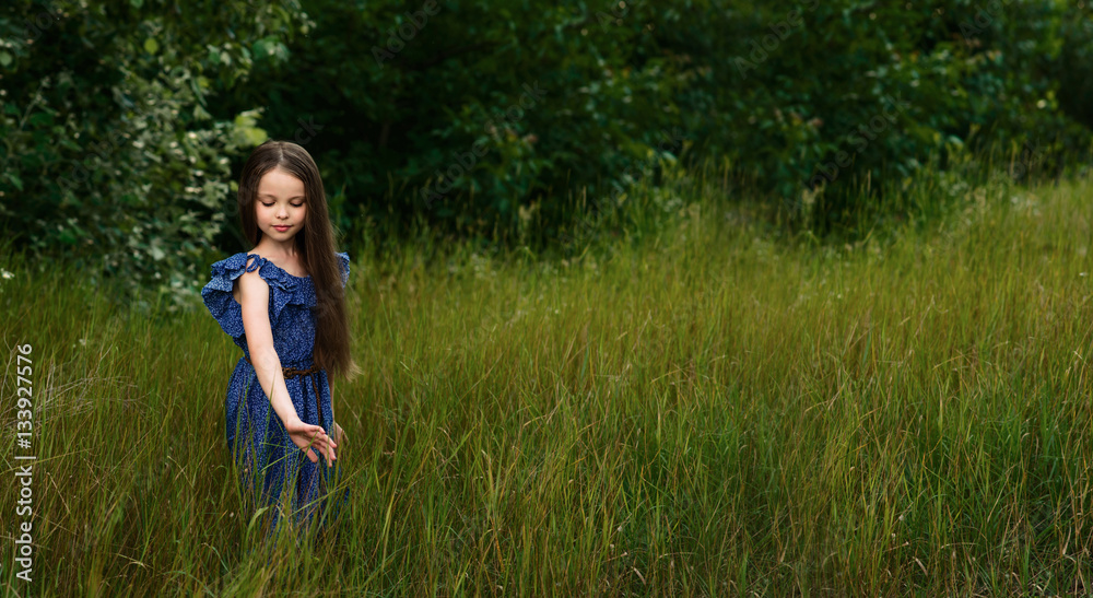 Pretty little girl relaxing outdoors on  summer vacation.