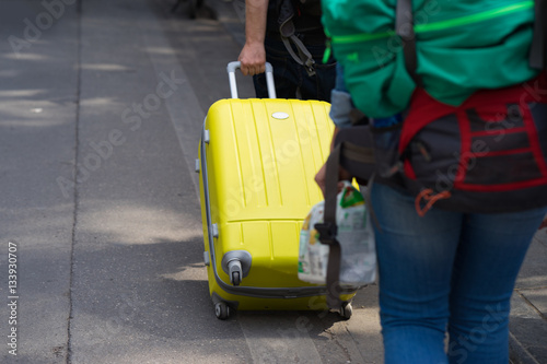 Yellow travel suitcase pulled by man hand on street. Concept of travel © Hanoi Photography