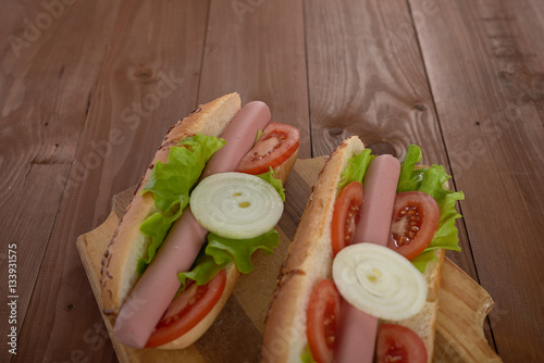 sandwich with sausage and vegetables on a wooden table
