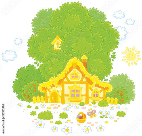 Small old hut with a thatched roof under a big green tree on Easter day