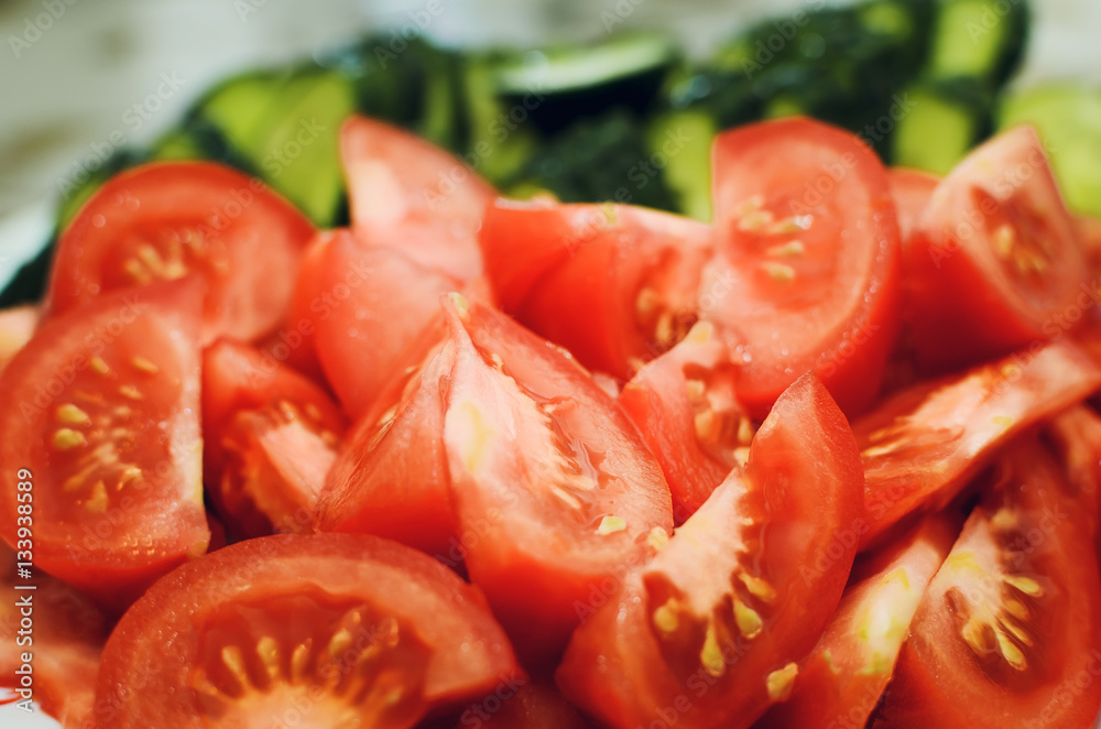 sliced tomatoes and cucumbers lie on a plate, close-up sliced tomatoes and cucumbers lie on a plate, close-up