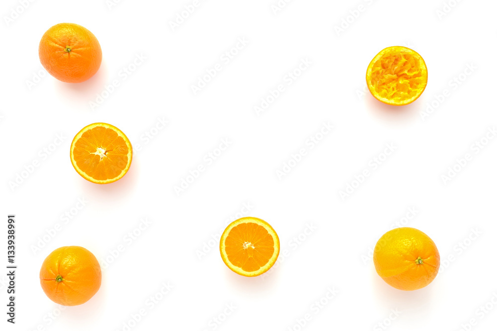 Closeup of whole, halved and squeezed oranges on white as food background with lots of copy space. Closeup of whole, halved and squeezed oranges on white as food background with lots of copy space.