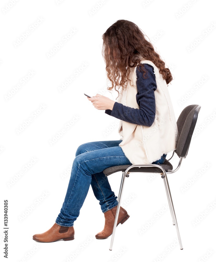 back view of woman sitting on chair and looks at the screen of t back view of woman sitting on chair and looks at the screen of t