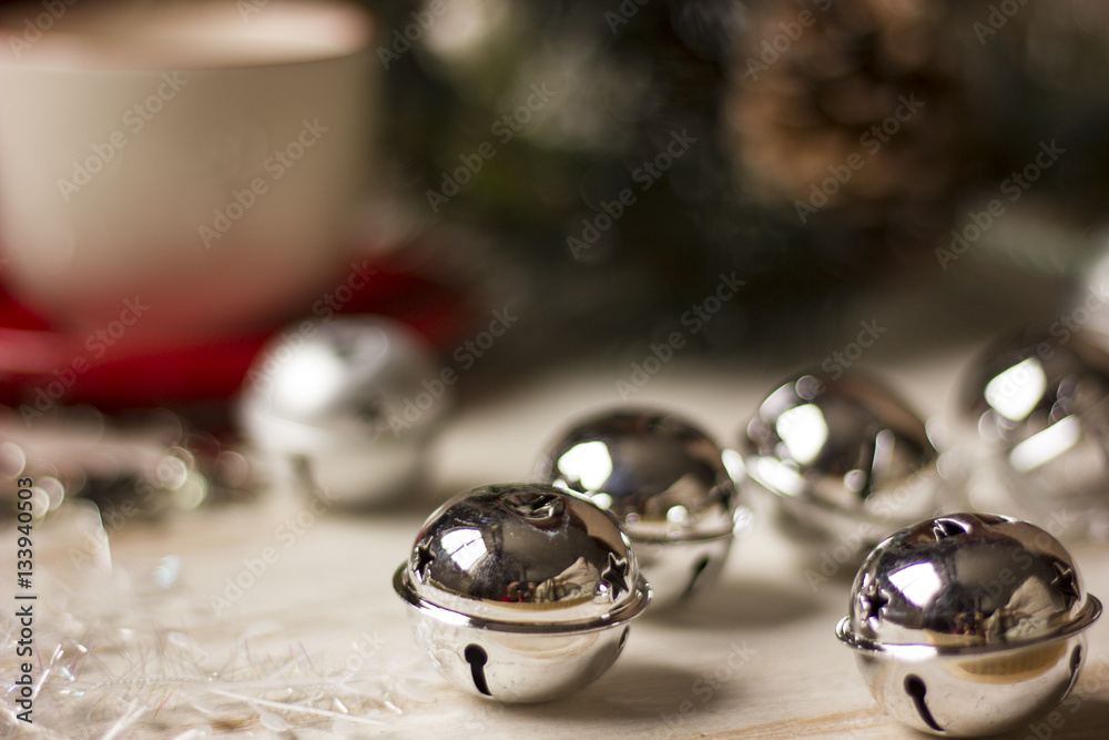 A beautiful christmas spirit background composition with a coffee -sup and jingle bells.