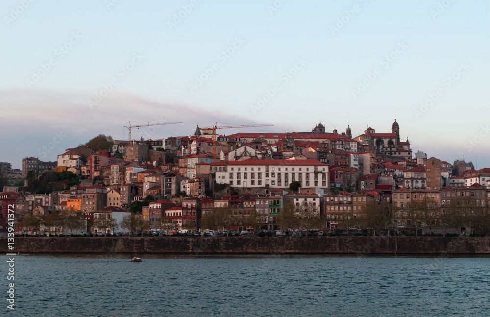 Portogallo, 26/03/2012: barche al tramonto e lo skyline di Porto con vista del fiume Douro tra le città di Porto e Vila Nova de Gaia