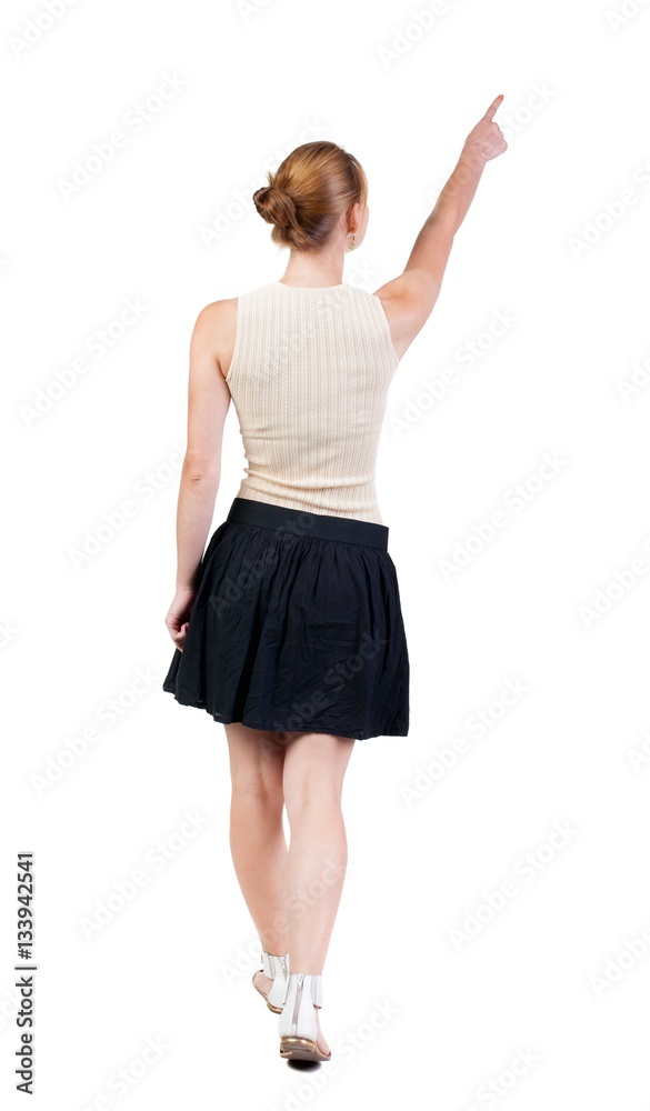 Naklejka premium back view of walking woman in dress. beautiful blonde girl in m