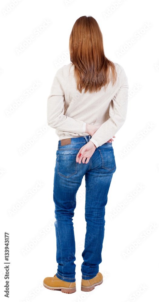 Obraz premium back view of standing young beautiful woman in jeans.