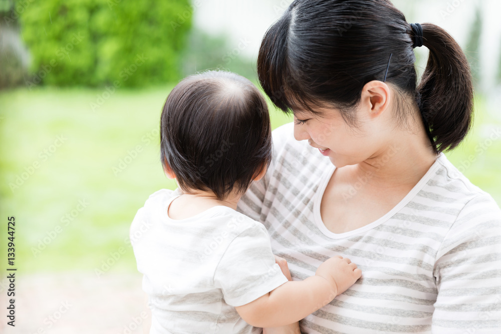 portrait of asian mother hugging baby in park portrait of asian mother hugging baby in park