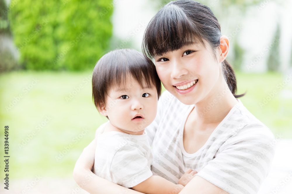 Obraz premium portrait of asian mother hugging baby in park