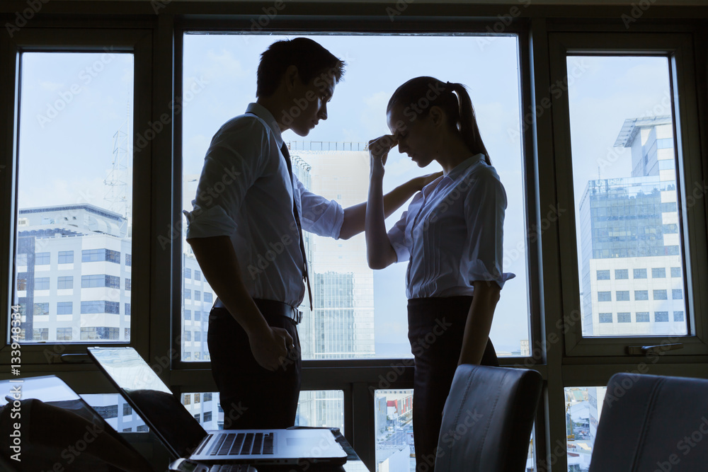 Fototapeta premium Businessman helping a businesswoman in a office setting. People helping each other concept. 